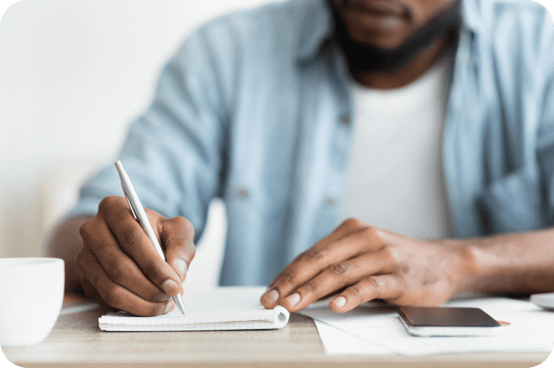 Man Writing In Notebook