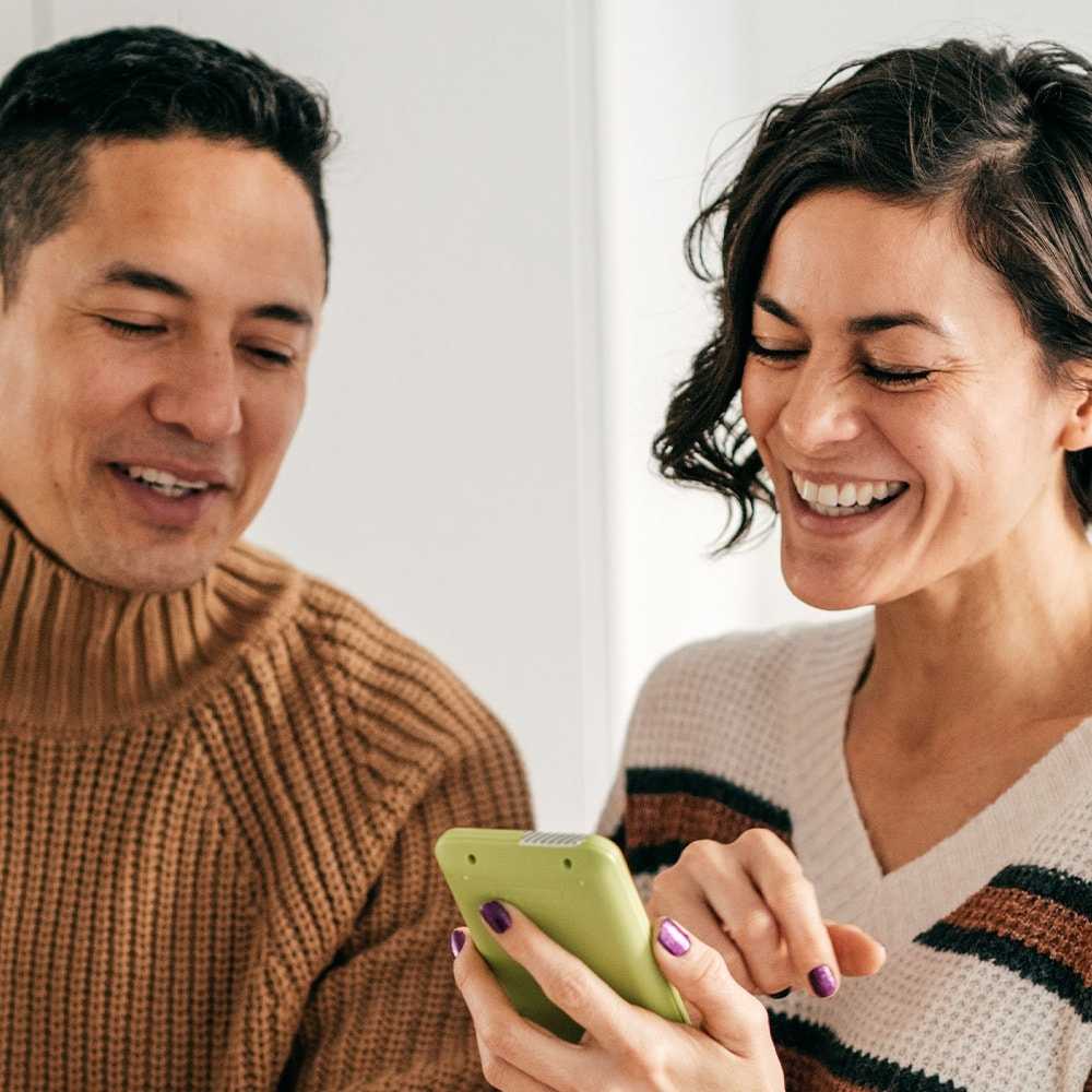 Couple reading phone and laptop